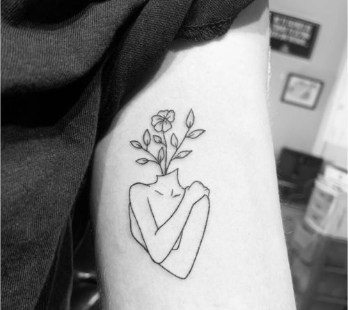 Self love  flower head woman tattoo on the tricep