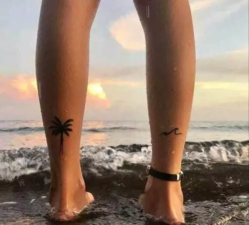 Minimalist beach tattoo on the upper arm