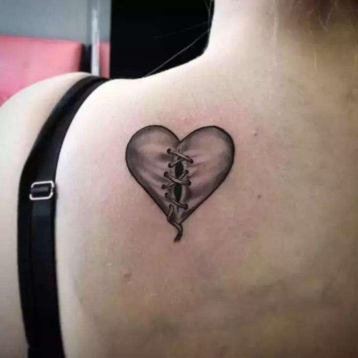 back-tattoo-of-heart-with-black-outlines-gray-shadows-heart-tattoo-on-hand-held-together-with-bandages-1