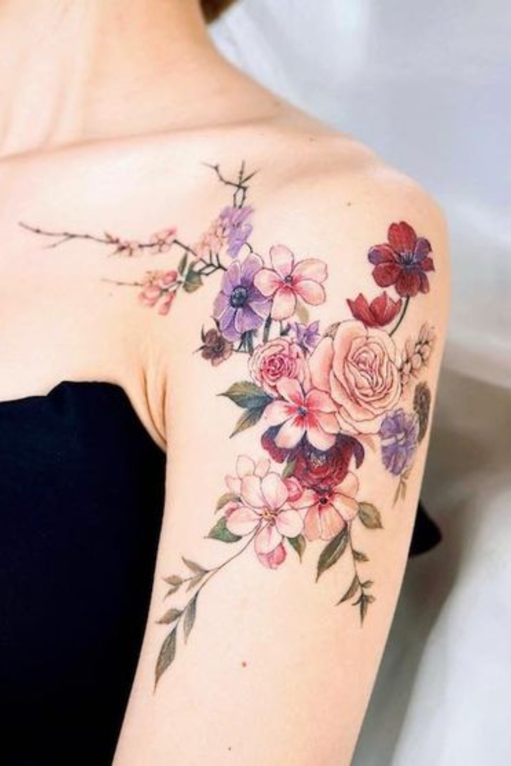 Colorful flower tattoo with roses on shoulder