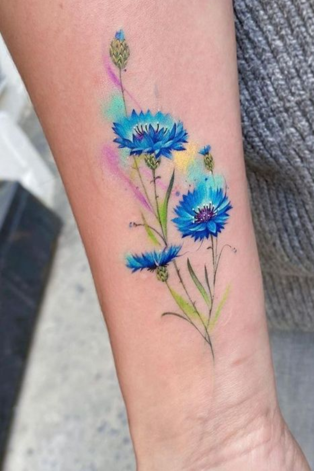 blue flower tattoo on forearm