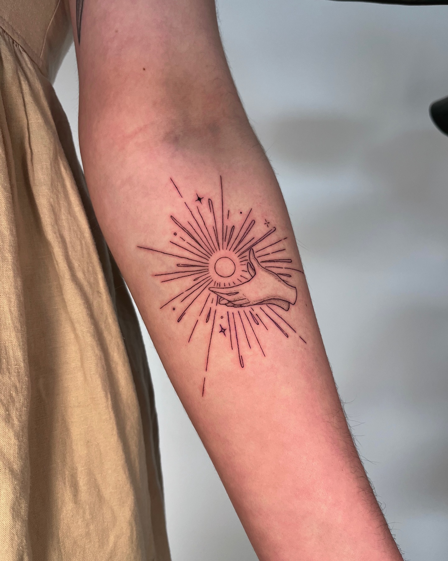 sun-in-hand-fine-line-tattoo