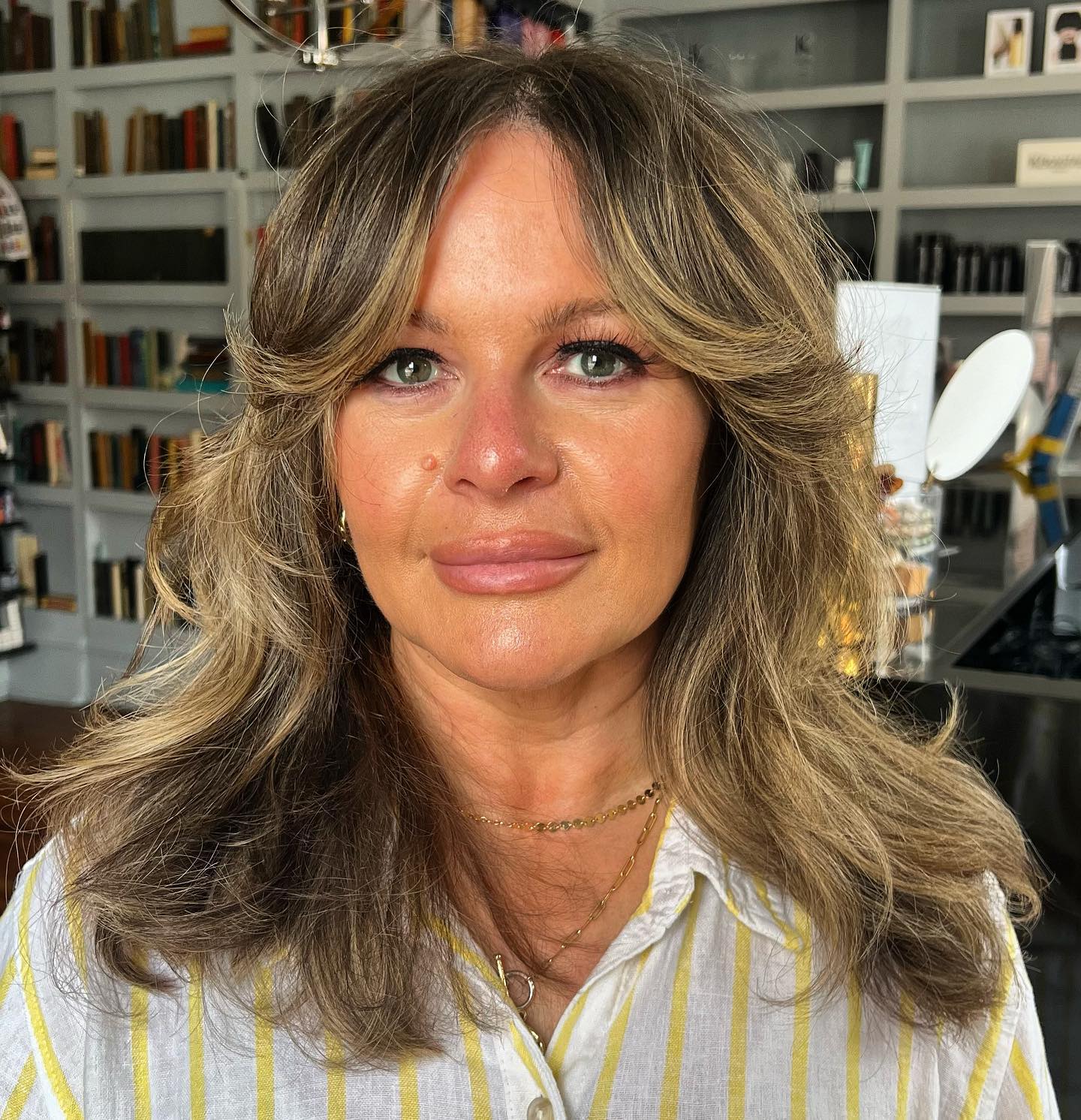 medium-length-shaggy-cut-with-curtain-bangs-and-highlights-for-older-women