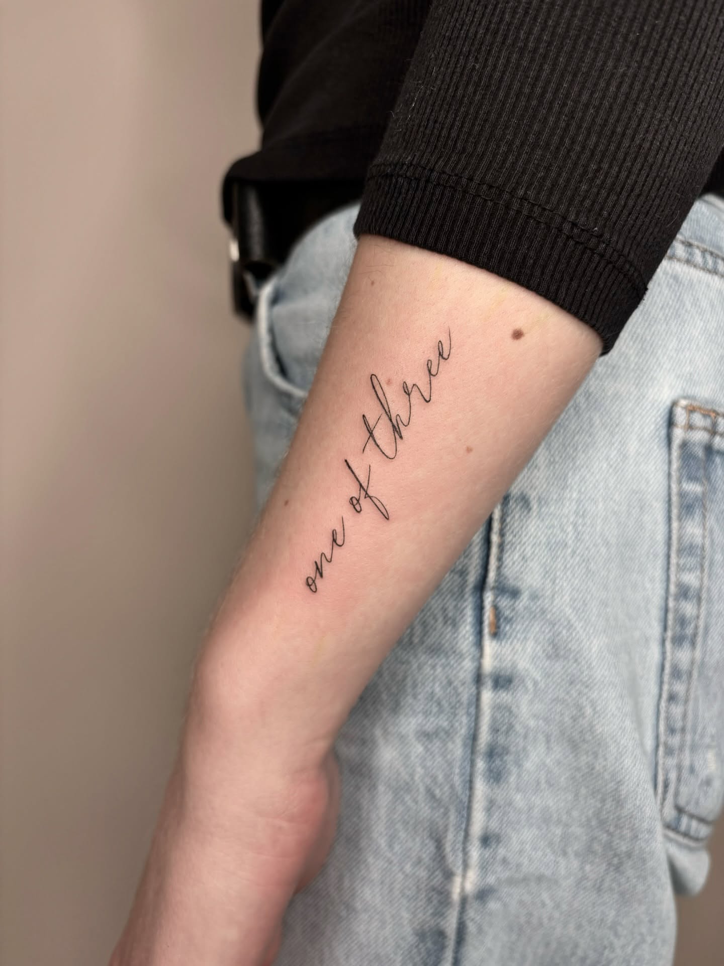 single-needle-one-of-three-word-tattoo
